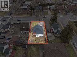 Aerial perspective showcasing a single-family residence with white siding and a dark shingle roof - 