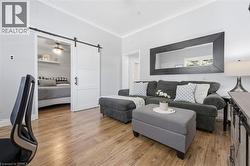 Open concept living space featuring wood-finish flooring, light gray wall paint, and white crown molding - 