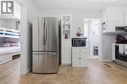 Kitchen area featuring neutral-toned floor tile and light gray walls - 