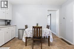 Eat-in kitchen featuring white cabinetry, light-toned countertops, and wood-finish flooring - 