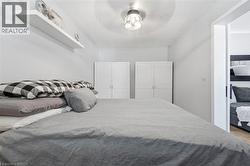 Bedroom with white walls and wood-finish flooring - 