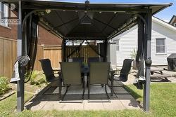 Outdoor gazebo with a dark metal frame, fabric canopy, and string lighting - 