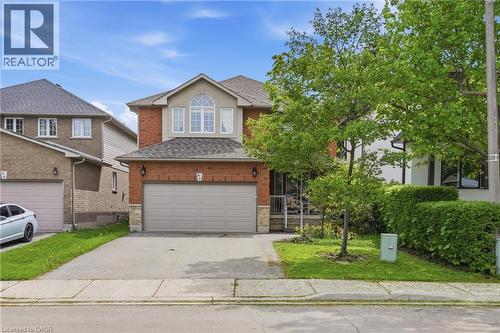 Brick and stucco exterior featuring a double-car garage with a paved driveway - 84 Duncairn Crescent, Hamilton, ON 