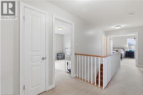 Upper-level hallway with neutral carpeting, light gray wall paint, and white trim - 84 Duncairn Crescent, Hamilton, ON 