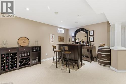 Dedicated entertainment space featuring a built-in wet bar with a dark wood countertop and a custom wine storage unit - 84 Duncairn Crescent, Hamilton, ON 