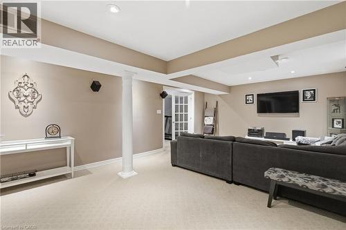 Finished recreation room featuring recessed lighting, light-toned carpet, a decorative support column, and a wall-mounted entertainment system - 84 Duncairn Crescent, Hamilton, ON 