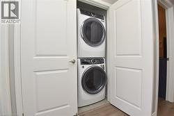 Dedicated laundry closet featuring a stacked washer and dryer - 