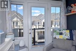 White door with integrated side windows opens to an exterior balcony featuring black metal railings - 