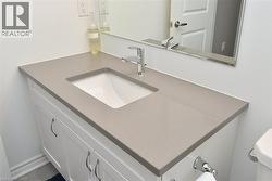 Bathroom vanity featuring a light gray countertop, integrated sink, and chrome faucet - 
