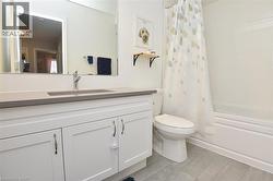 Bathroom featuring a single vanity with shaker-style cabinetry, an integrated rectangular sink, and a chrome faucet - 