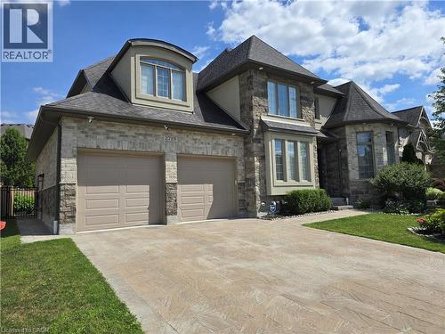 Stone and brick exterior with a multi-gabled roofline - 2719 Torrey Pines Way, London, ON 