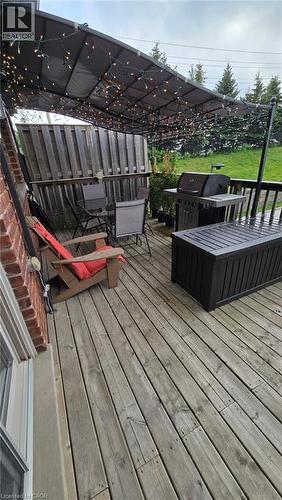 Outdoor wood-finish deck with a privacy fence and a dark-toned awning - 4 Isaiah Drive, Kitchener, ON 