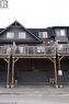 Multi-level townhome featuring brick and shingle siding, a prominent gabled roofline, and a private wooden deck - 4 Isaiah Drive, Kitchener, ON 