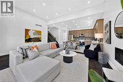 Open-concept living area featuring dark wood-finish flooring and recessed lighting - 
