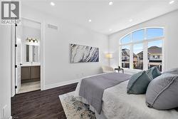 Bedroom featuring dark wood-finish flooring and an arched window - 