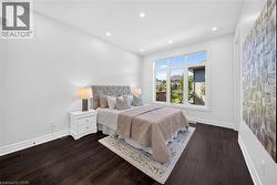 Spacious room featuring dark wood-finish flooring and a large multi-pane window - 