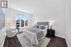 Room featuring a prominent arched window, dark wood-finish flooring, recessed ceiling lighting, and crisp white walls - 