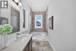 Bathroom featuring a built-in tub with a window above, complemented by full-height wall tiling - 