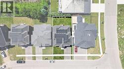 Aerial view showcasing a residential property with a dark shingle roof and a green lawn - 