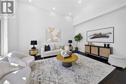 Spacious living area featuring high vaulted ceilings, recessed lighting, large windows, dark wood-finish flooring, and a built-in media console - 