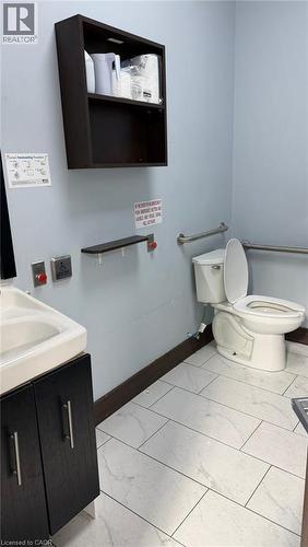Restroom featuring a wall-mounted shelving unit, contemporary vanity with integrated sink, and horizontal grab bars - 9 Beaumaris Drive Unit# B4, Brampton, ON 