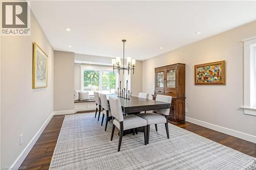 Dining area featuring dark wood-finish flooring, recessed lighting, and a chandelier - 23 Mackenzie Drive, Georgetown, ON 