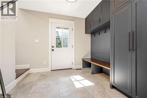 Mudroom featuring slate gray built-in cabinetry, a dark wood-finish bench, and coat hooks - 23 Mackenzie Drive, Georgetown, ON 