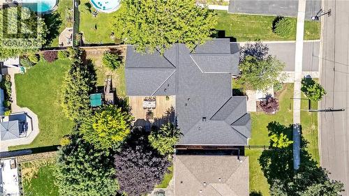 Expansive property featuring a grey shingle roof, a large rear deck, a paved driveway, and mature landscaping - 23 Mackenzie Drive, Georgetown, ON 