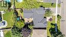 Expansive property featuring a grey shingle roof, a large rear deck, a paved driveway, and mature landscaping - 23 Mackenzie Drive, Georgetown, ON 