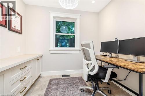 Dedicated workspace featuring a window with white trim, built-in lower cabinetry with a light-toned countertop, recessed lighting, and a contemporary ceiling fixture - 23 Mackenzie Drive, Georgetown, ON 