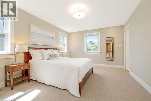 Carpeted bedroom featuring multiple windows, recessed lighting, and a neutral color palette - 23 Mackenzie Drive, Georgetown, ON 