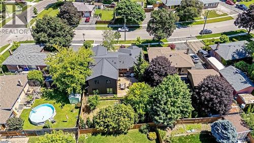 Aerial perspective showcasing a residential property with a dark-clad exterior, a spacious rear deck, and a manicured lawn - 23 Mackenzie Drive, Georgetown, ON 