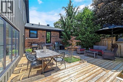 Multi-level wood deck featuring a built-in planter, brick exterior, and a privacy fence - 23 Mackenzie Drive, Georgetown, ON 