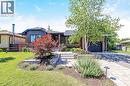 Modern bungalow exterior featuring varied siding, a dark garage door, and a paver driveway - 23 Mackenzie Drive, Georgetown, ON 