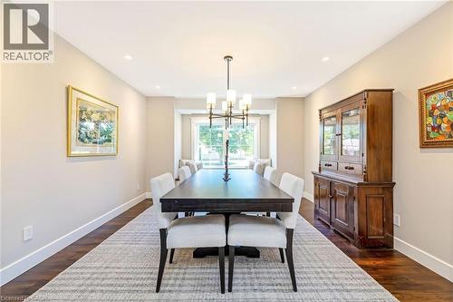 Dining area featuring wood-finish flooring, recessed lighting, and a contemporary chandelier - 23 Mackenzie Drive, Georgetown, ON 