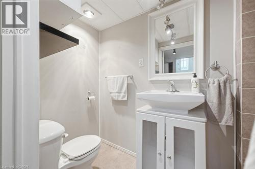 Bathroom featuring a white rectangular vessel sink atop a white vanity with clear-paneled doors, a framed mirror, and chrome fixtures - 14 Gateway Drive, Guelph, ON 