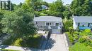 Dormer-style residence featuring a gray facade, integrated garage, and a long concrete driveway - 14 Gateway Drive, Guelph, ON 