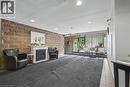 Inviting lobby area featuring a stone accent wall, decorative fireplace with white mantel, recessed lighting, and a glass-paneled entrance - 175 E Hunter Street E Unit# 401, Hamilton, ON 