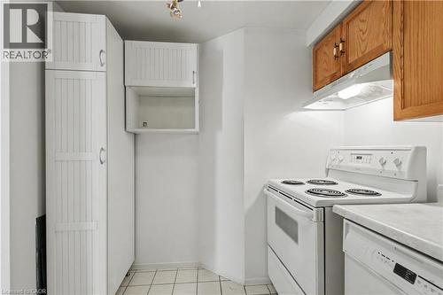 White kitchen featuring a range, dishwasher, and wood cabinetry - 175 Hunter Street E Unit# 401, Hamilton, ON - Indoor Photo Showing Kitchen