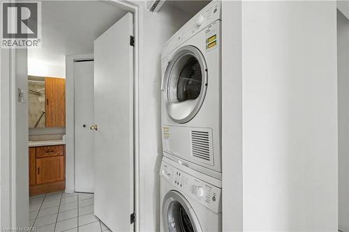 Dedicated laundry area featuring a stacked washer and dryer unit - 175 Hunter Street E Unit# 401, Hamilton, ON - Indoor Photo Showing Laundry Room