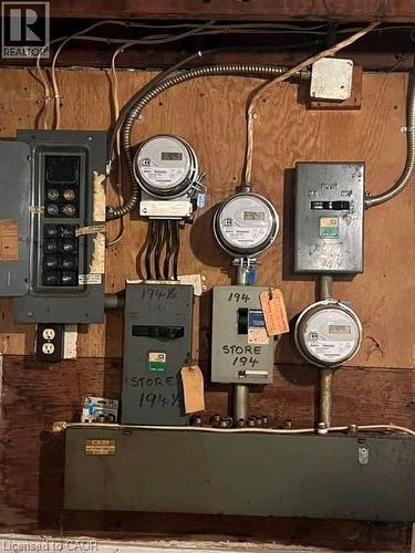 Electrical panel and multiple utility meters on a wood-paneled wall - 194 Kenilworth Avenue N, Hamilton, ON 
