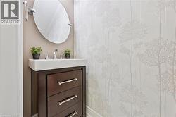 Vanity featuring a rectangular sink, chrome faucet, and a dark wood-finish cabinet with three drawers and brushed nickel hardware - 