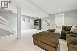 Finished lower level featuring recessed lighting, light gray wall paint, white trim, and a white paneled door - 