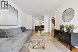 Bright living area with wood-finish flooring, white walls, and an open layout - 
