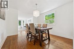 Dining area featuring wood-finish flooring, white baseboards, and a crystal chandelier - 