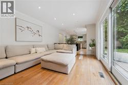 Bright living area with wood-finish flooring and recessed lighting - 