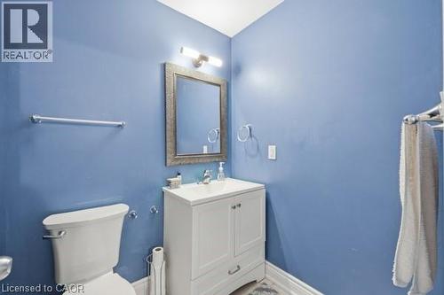 Bathroom with a white vanity and integrated sink, framed mirror, and chrome fixtures - 16 Harrison Avenue, Hamilton, ON 