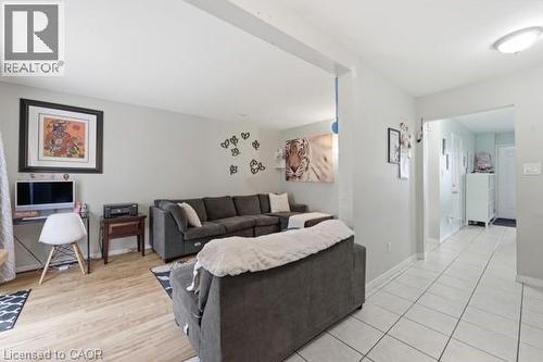 Open concept living area featuring light wood-finish flooring, neutral wall tones, and a recessed ceiling light - 16 Harrison Avenue, Hamilton, ON 