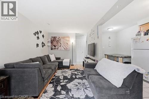 Open-concept living space featuring wood-finish flooring, recessed lighting, and a neutral wall color palette - 16 Harrison Avenue, Hamilton, ON 