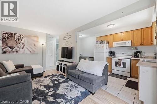 Combined living area and kitchen featuring light wood-finish flooring, white wall paint, and recessed lighting - 16 Harrison Avenue, Hamilton, ON 